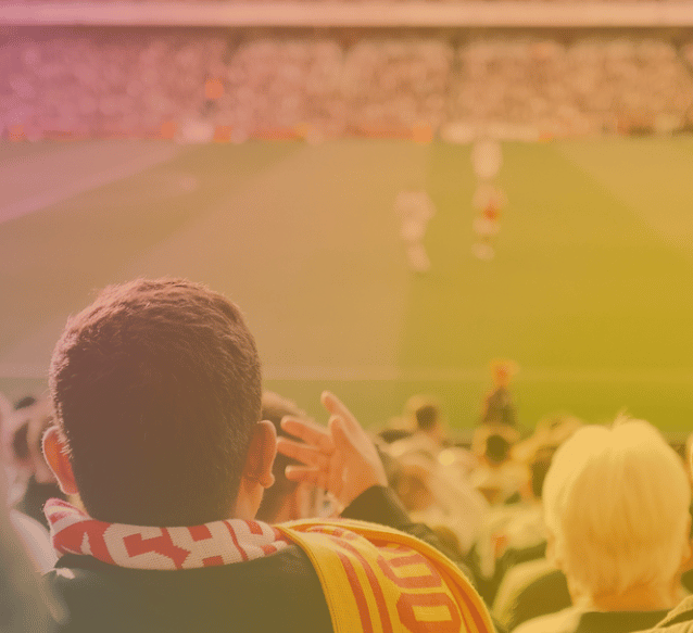 A man in a scarf watching a football match